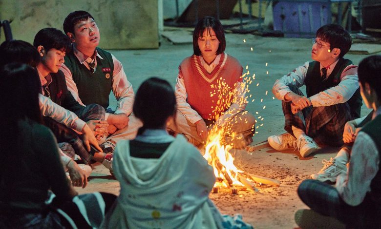 The cast “All of us are Dead” gathered around a fire.